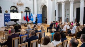 Inauguracja Polskiej Sieci Miast i Społeczności Przyjaznych Osobom Starszym w Ministerstwie Zdrowia w Warszawie - sala konferencyjna z uczestnikami i prelegentką przy mównicy
