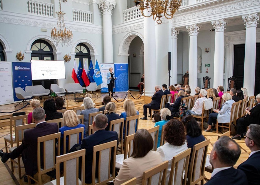 Inauguracja Polskiej Sieci Miast i Społeczności Przyjaznych Osobom Starszym w Ministerstwie Zdrowia w Warszawie - sala konferencyjna z uczestnikami i prelegentką przy mównicy