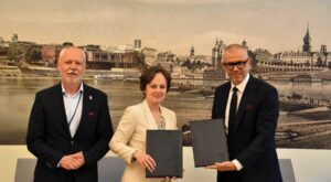 Podpisanie umowy między Wodociągami Warszawskimi a T-Mobile Polska na budowę systemu zdalnego odczytu wodomierzy IoT - przedstawiciele obu firm trzymają teczki z dokumentami