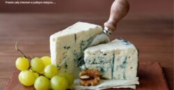 Kawałek sera blue cheese z niebieską pleśnią na drewnianej desce do serwowania