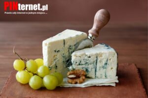 Kawałek sera blue cheese z niebieską pleśnią na drewnianej desce do serwowania
