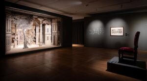 Zbliżenie na zrekonstruowaną barokową scenę teatralną z motywem drzewa i architektury