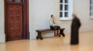 Miniaturowa figurka mężczyzny na ławce z wystawy Trefl Miniatury w Gdyni